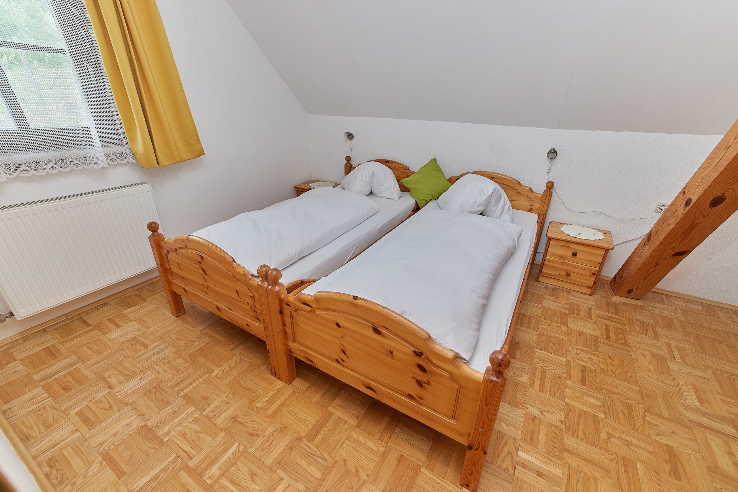 Das zweite Doppelbettzimmer der Wohnung Sunnseitn hat wie alle anderen Räume einen Parkettboden